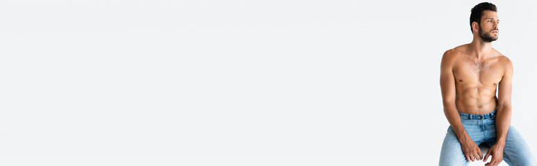 Fototapeta premium shirtless and bearded man sitting and looking away isolated on white