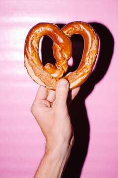 Hand holding heart-shaped pretzel
