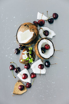 Still life flat lay of fresh coconut and cherries with cherry bl
