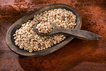 Uncooked dried lentils in a wooden bowl - Lens culinaris