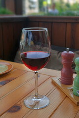 Glass with dry red wine on a table in a cafe close-up.