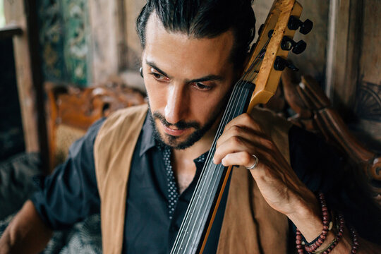 Man playing cello on his wooden terrace