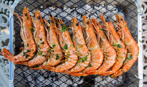 KIng prawns in a row on a barbecue