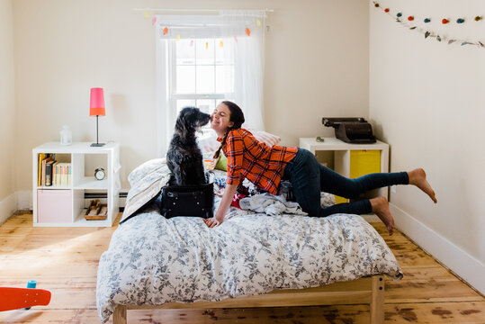 teen packing her suitcase with her dog