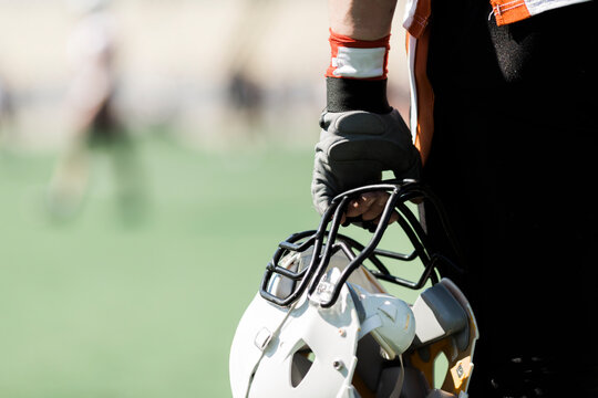 hand of player with used white helmet and glove, selective focus