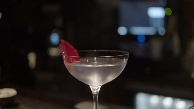 Cocktail with rose petal as decoration, slider shot with zoom in