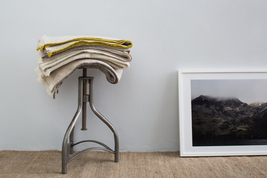 Stool with stack of wool blankets and framed photo