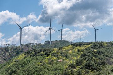 Wind turbines in a mountain with green trees
