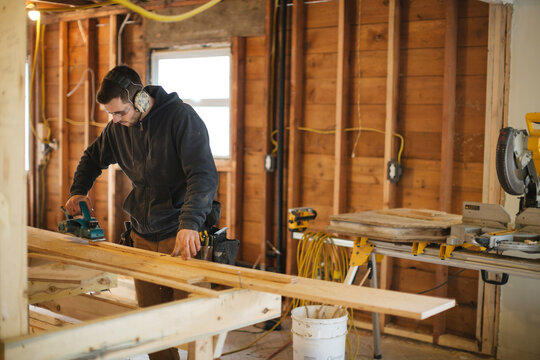 Carpenter man working on jobsite plainer