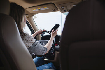 woman driving while holding a cell phone