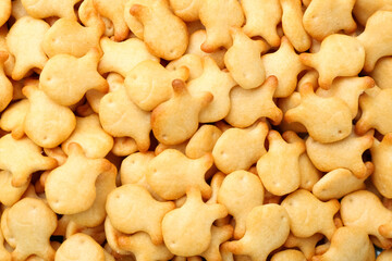 Delicious goldfish crackers as background, closeup view