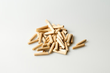 pile of wooden dowels on white table, carpentry connectors, selective focus