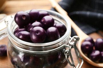 Jar with fresh acai berries on table, closeup