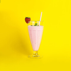 Tasty fresh milk shake with strawberry on yellow background