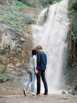 Couple kissing at waterfall