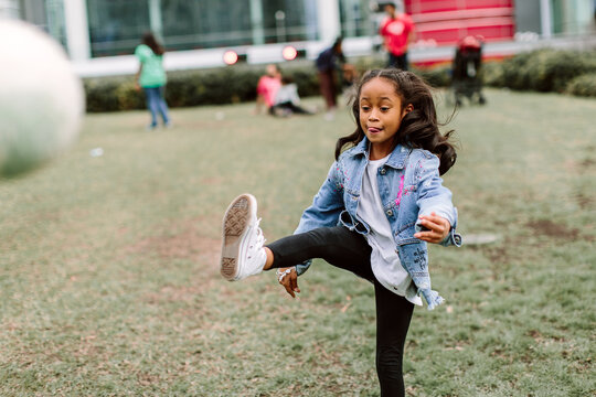 Action shot of a young girl kicking a soccer ball.