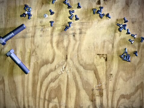Fondo de madera con tornillos y pernos met&aacute;licos dispersos y espacio libre para texto