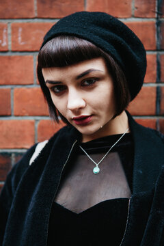 Cute gothic woman in front of brick wall