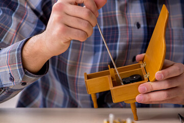 Young male watchmaker working in the workshop