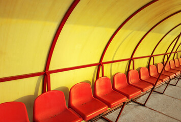 red line of chairs on yellow background