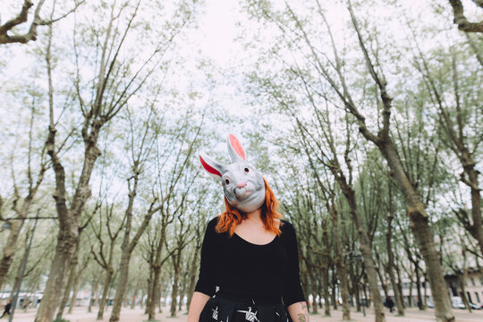 woman wearing a bunny mask between trees