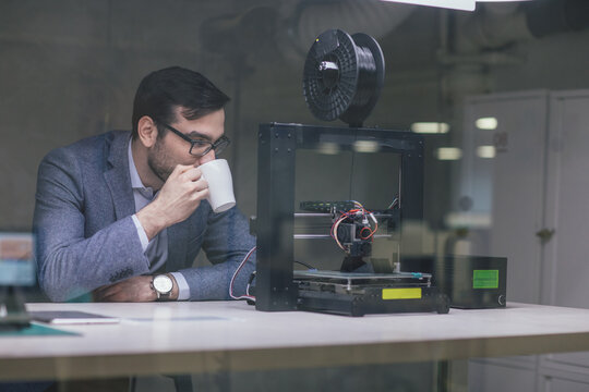 Businessman Looking at 3D Printer