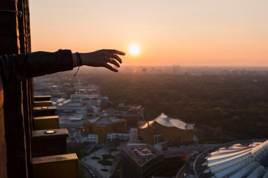 Female hand over sunset in Berlin