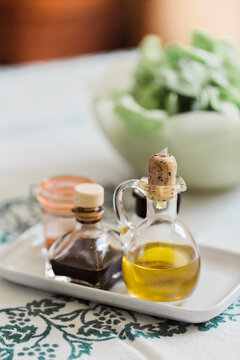 Olive oil and vinegar bottles on seasonings porcelain tray on table