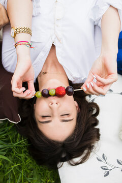 Young woman eating fruits on a picnic