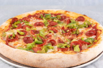 Healthy sized pepperoni and green pepper pizza with thick crust to complete a delicious meal to eat