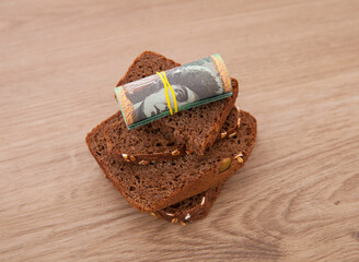 A roll of Australian dollar banknotes and black bread