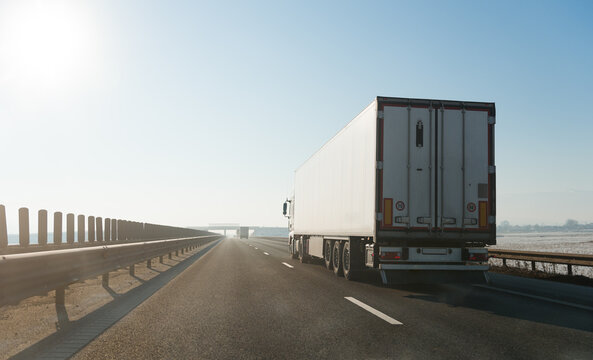 Large white truck driving on highway on a bright sunny day
