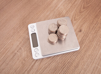 Obraz na płótnie Canvas Precision electronic scale and weighed coins