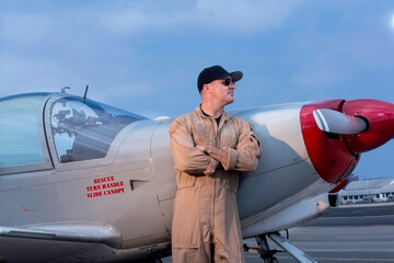Fighter pilot standing next to Marchetti SIAI SF260 fighter propeller airplane  looking camera right