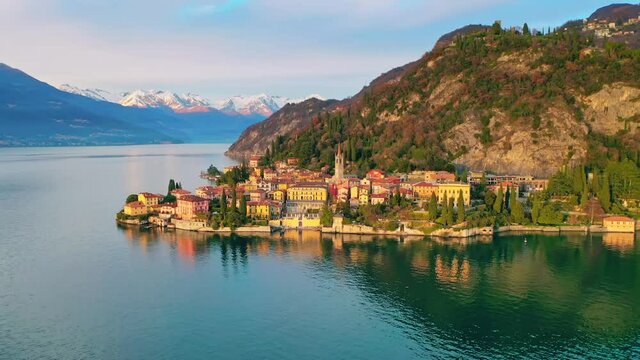 Italian Lake Como and Varenna town landscape at sunset, Alps snowy mountain background