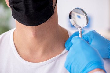 Young man visiting experienced doctor dermatologist