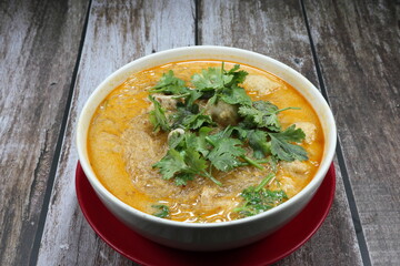 Hot and Spicy soup of vermicelli with shrimp ball and topping with green coriander in the bowl. Famous traditional sour and spicy soup in Asia restaurant. 