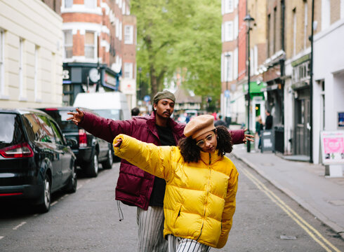 Cool couple wearing vivid puffer jackets in the street in London