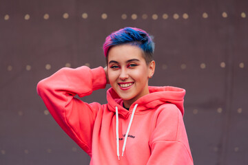 Portrait of a young girl with short colorful hair and nose piercing