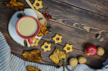 cup of cocoa acorns rowan leaves top view, autumn warming drink, coffee with milk or cappuccino