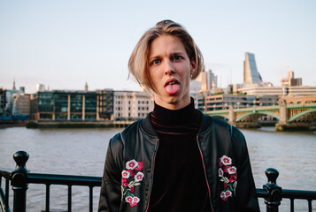 Attractive blonde man in front of the River Thames in London