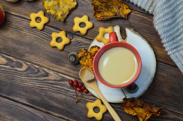 cup of cocoa acorns rowan leaves top view, autumn warming drink, coffee with milk or cappuccino