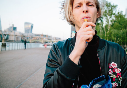 Attractive blonde man in front of the River Thames in London