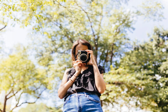 Young Girl With a Vintage Film Camera In Central Park. New York