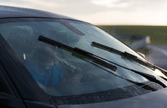 Man washing car windows inside