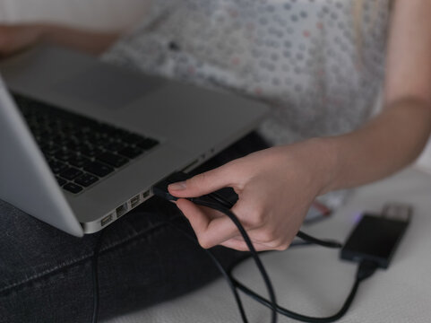 Woman plugging card reader to laptop