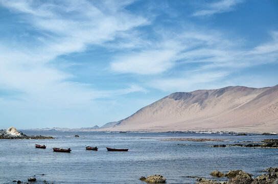 Boat at the bay next to desert mountain