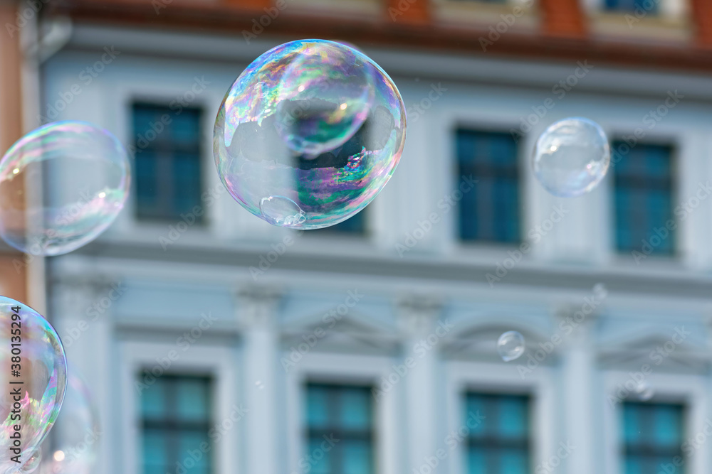 Poster selective focus shot of bubbles with a building background