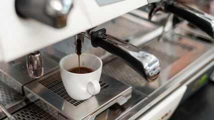 black coffee in white cup put on coffee maker