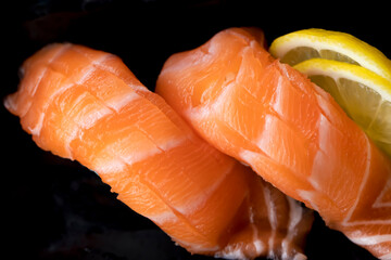 Fresh salmon sushi on a wooden plate with seaweed salad and sweet egg sushi. Sushi menu. Japanese food.